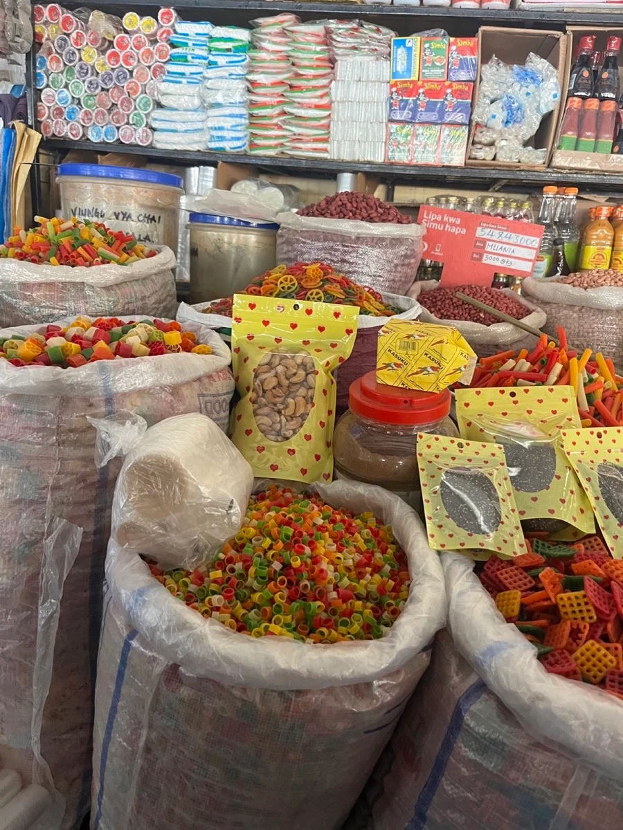 Colorful pasta, grains, legumes, and packaged goods at a Tanzanian market stall