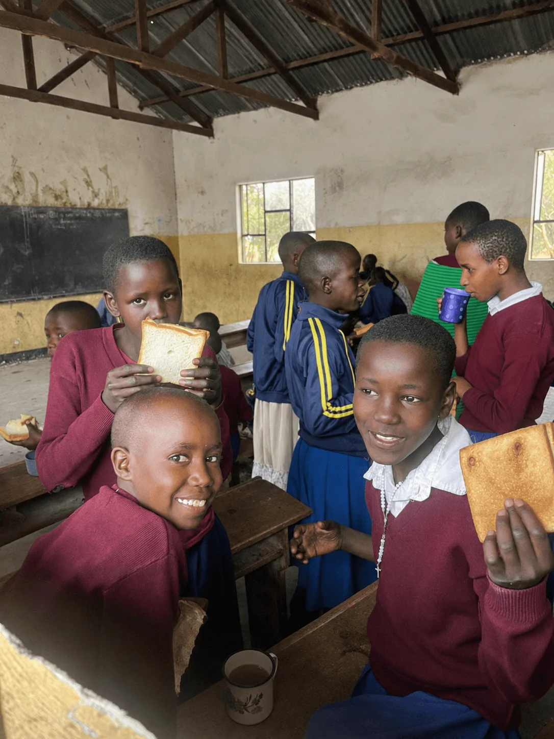Children sharing a meal inside a Tanzanian classroom